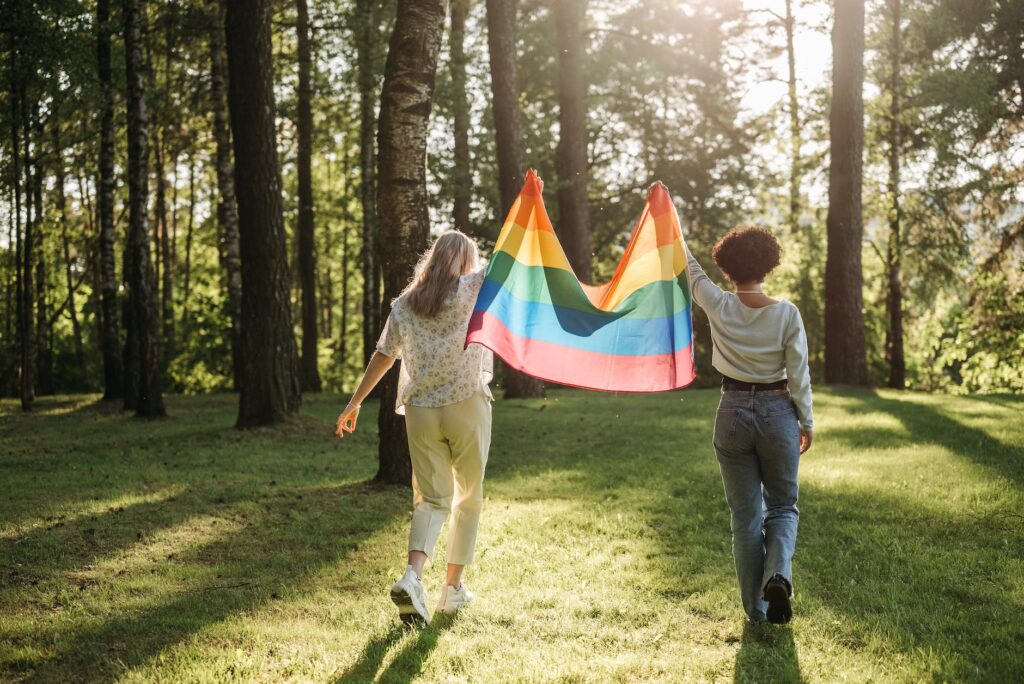 back view of two women holding a rainbow flag